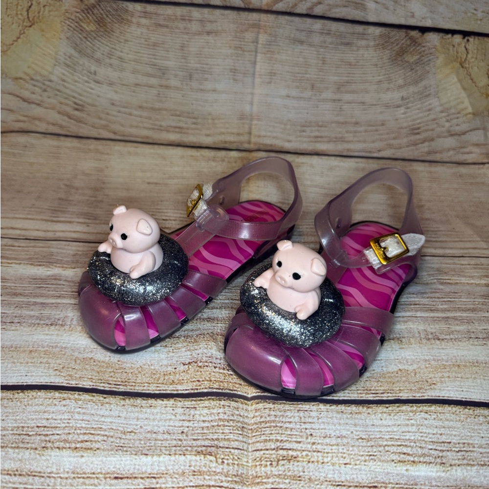 Mini Melissa piggies in a pool float sandals